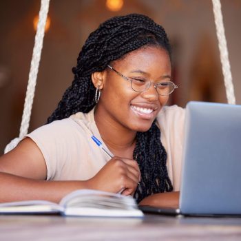 Happy, class and black woman doing elearning on a laptop, studying and learning with notes. Educati.